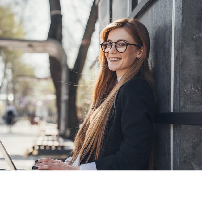 Professional young woman using a laptop outside